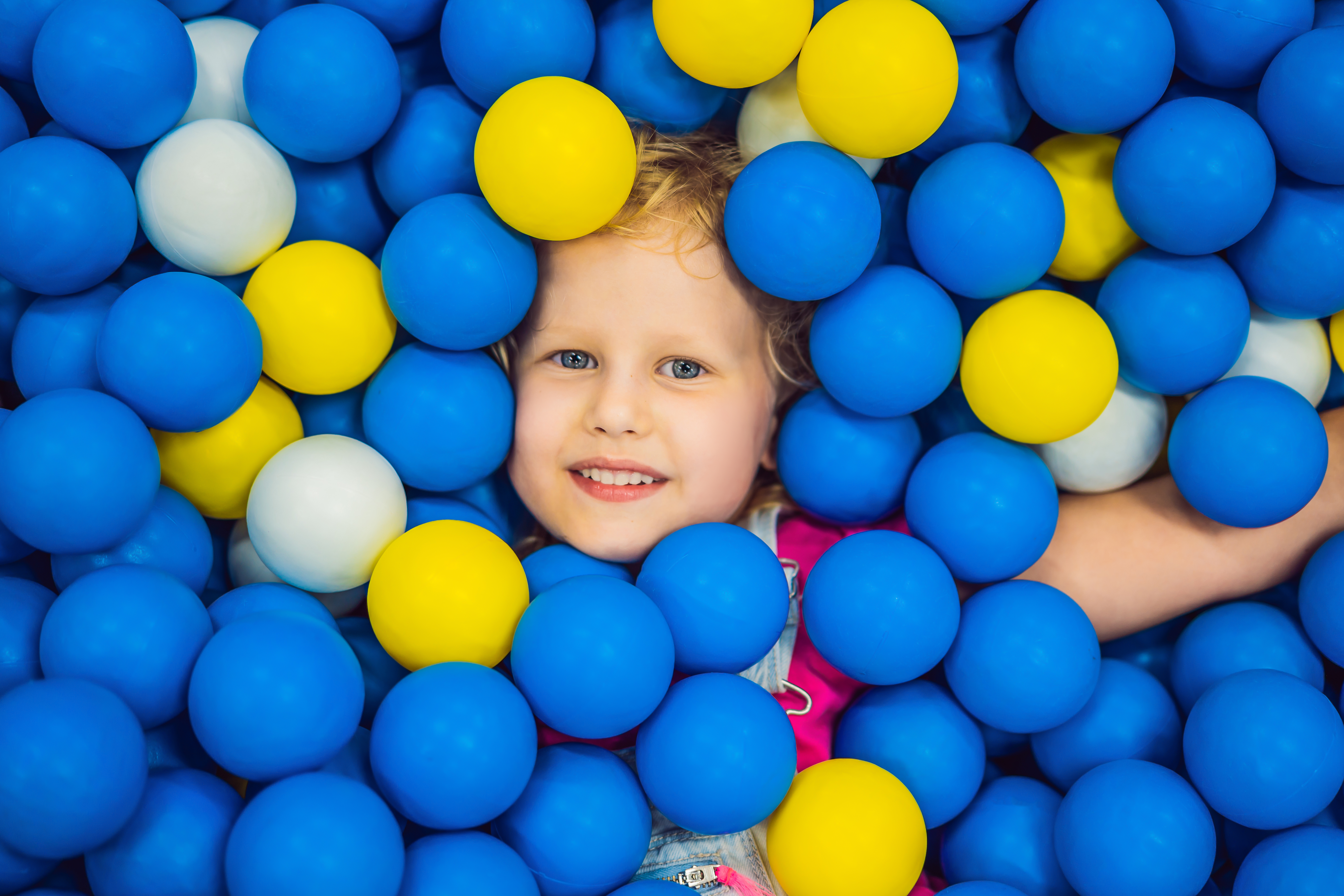 Happy child playing in a soft play ball pit